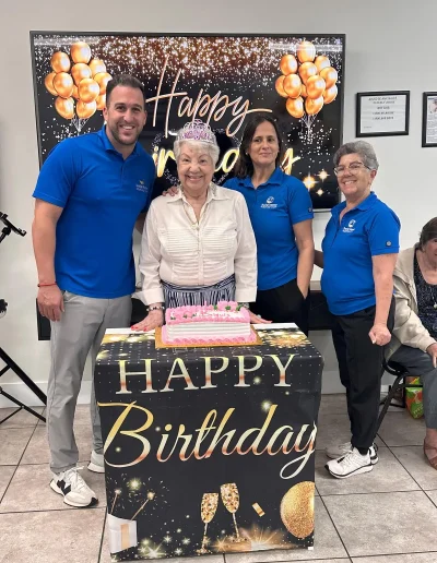 Senior participant celebrating her birthday with Social Center Adult Day Care staff