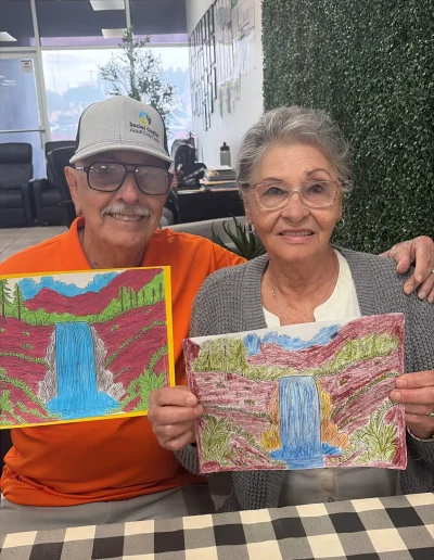 Senior couple showing their artwork during an art activity at Social Center Adult Day Care