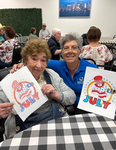 Senior participants showing July artwork during activities at Social Center Adult Day Care