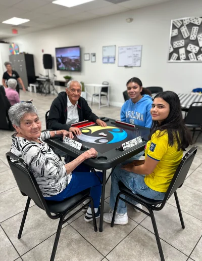 Seniors and staff playing dominoes together at Social Center Adult Day Care